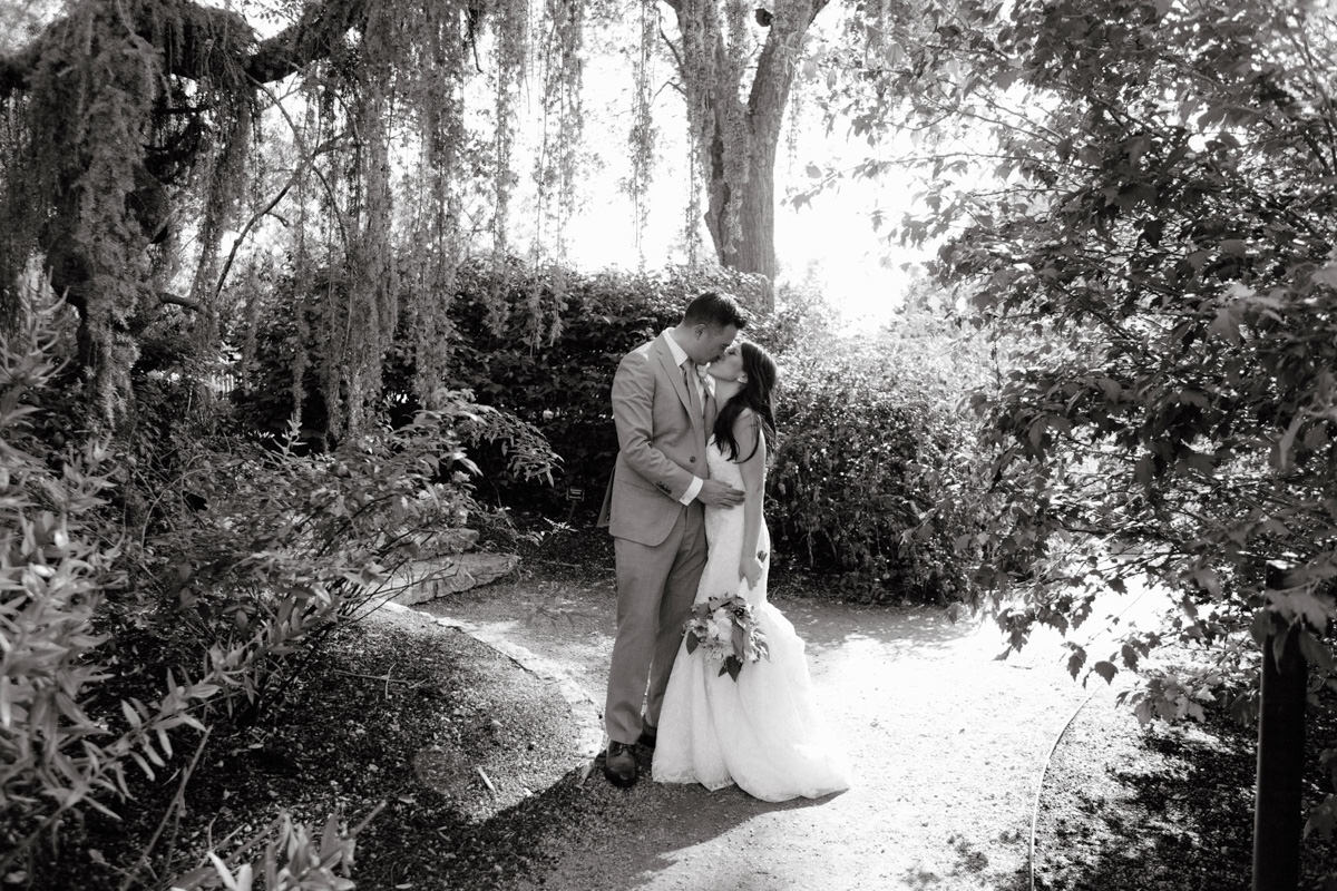 Bride and groom kiss at the Dallas Arboretum, taken by NYC wedding photographer Jenny Fu