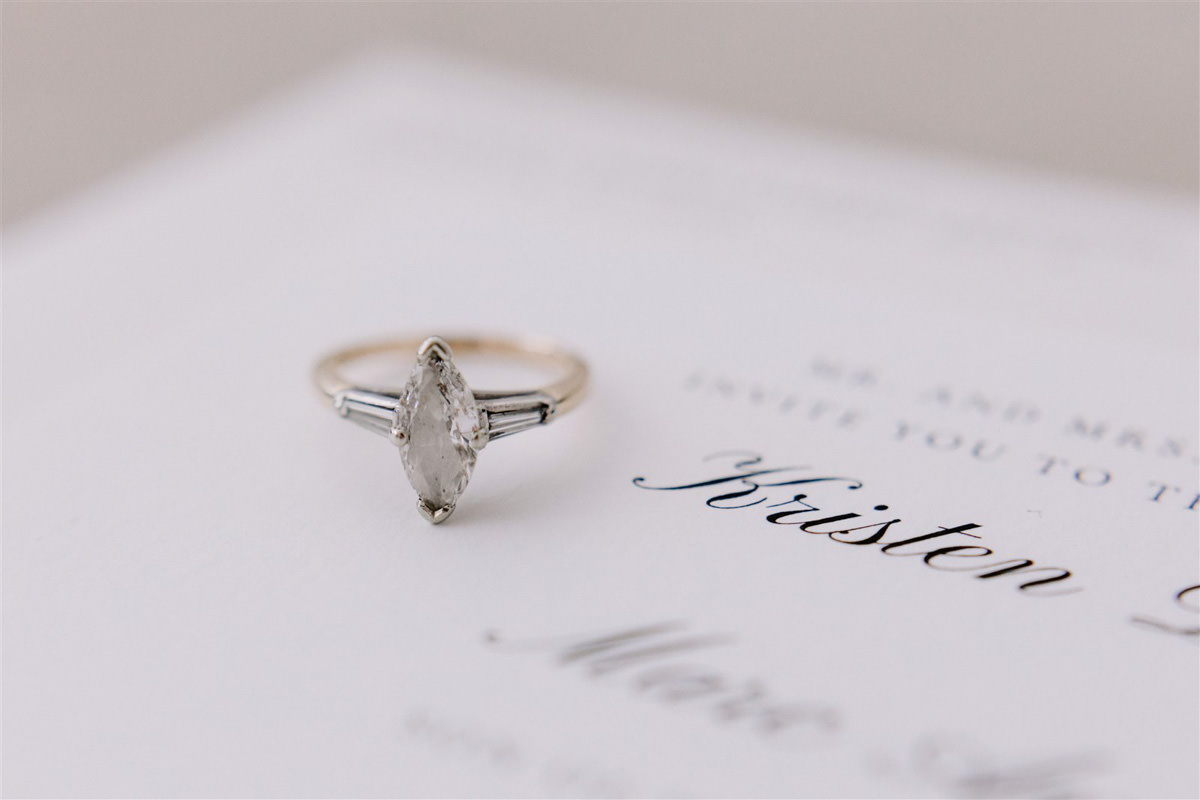 A professional wedding photographer takes a picture of a solitaire wedding ring
