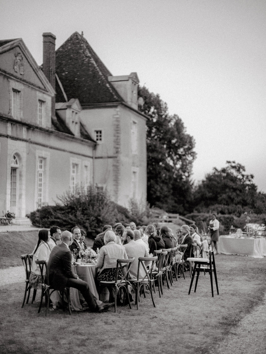 Wedding Planner for Destination Wedding | Guests of a destination wedding in France sit at a long table in a garden