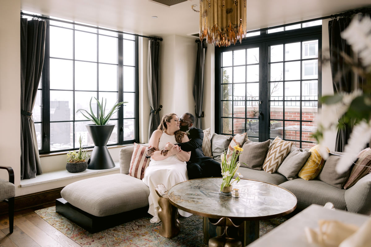 A biracial couple sits in a Lower Manhattan hotel for wedding photos