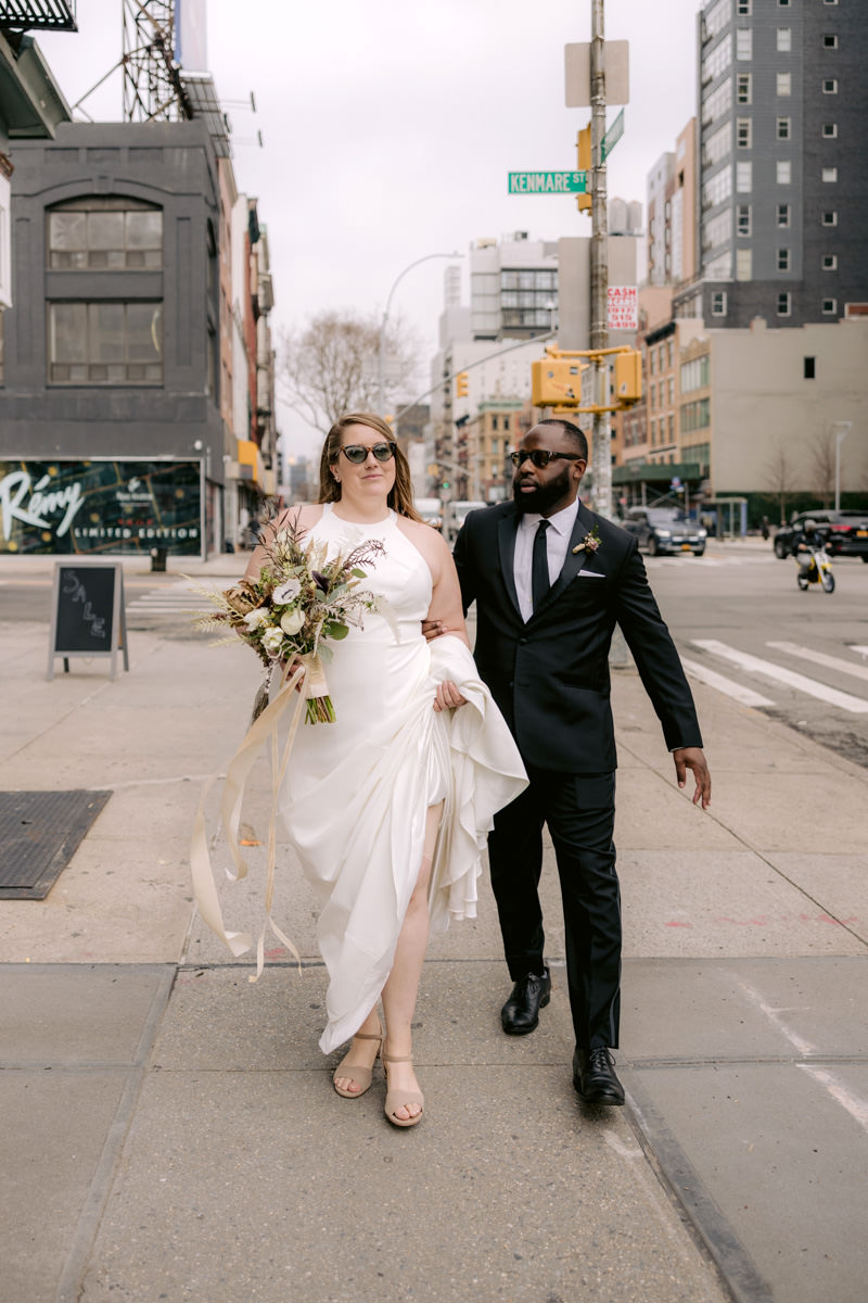 Bride and groom walk down the street in Lower Manhattan on their wedding day