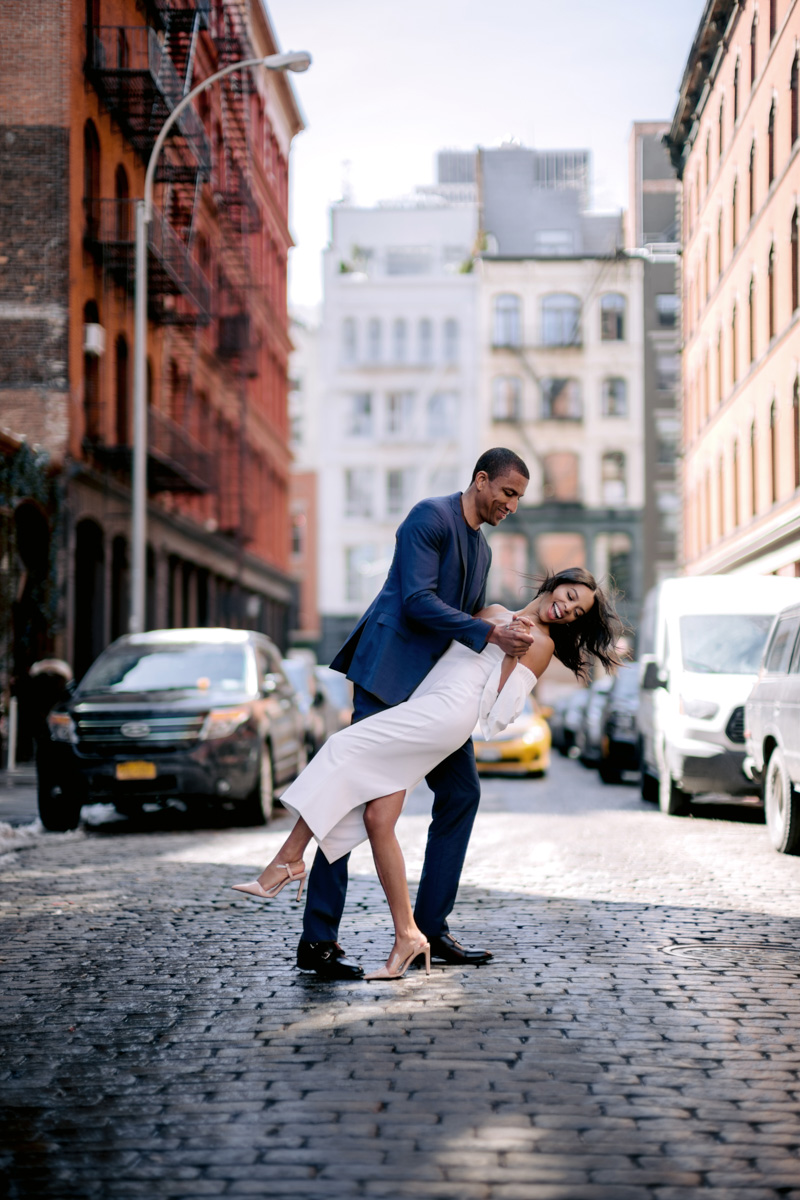 A bride and groom dance on cobblestone streets in Lower Manhattan