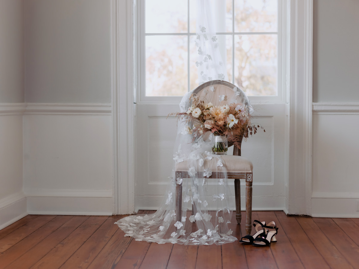 A brides bouquet sits on a chair, organized by her wedding planner