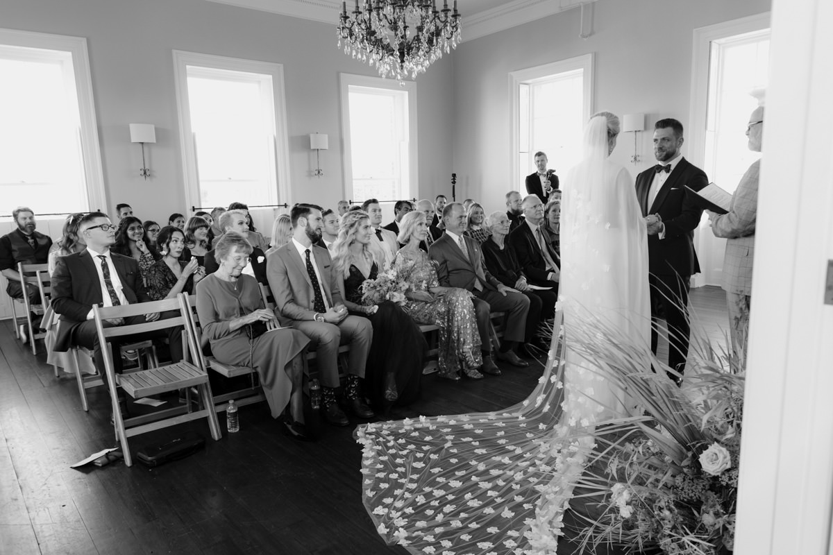 A bride and groom being married in an old home with vintage chandeliers