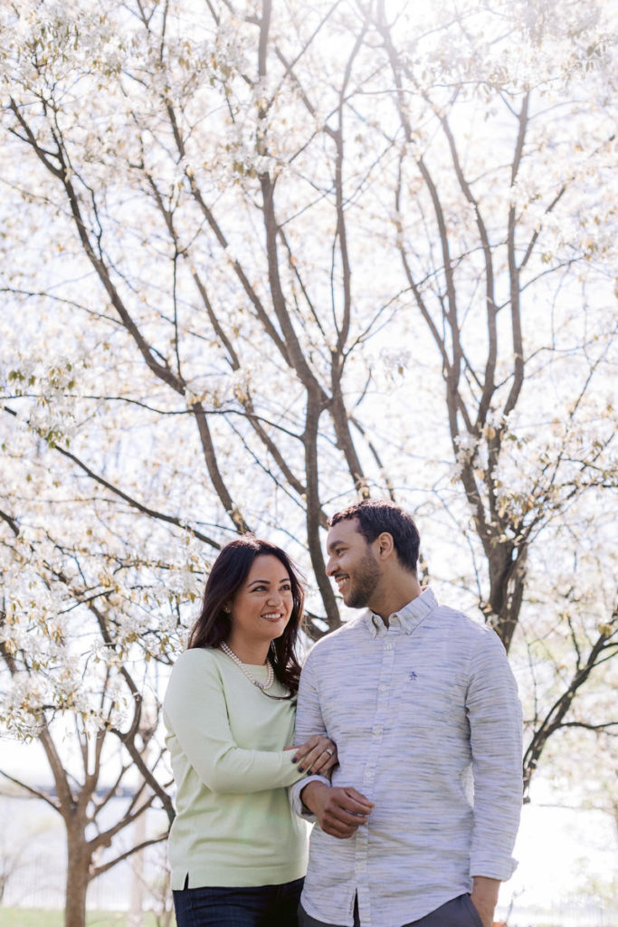 A man and woman in front of a cherry blossom tree