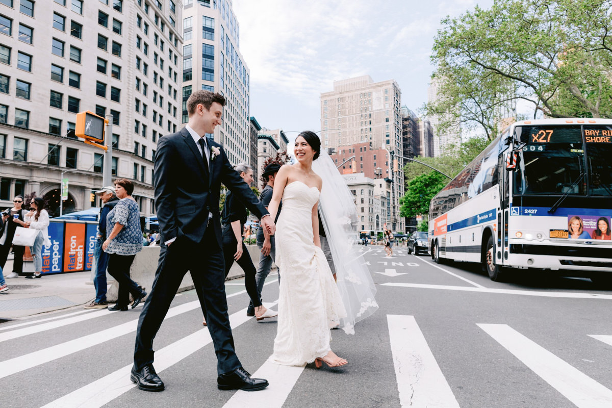 A bride and groom use a crosswalk in New York City on the way to their wedding reception