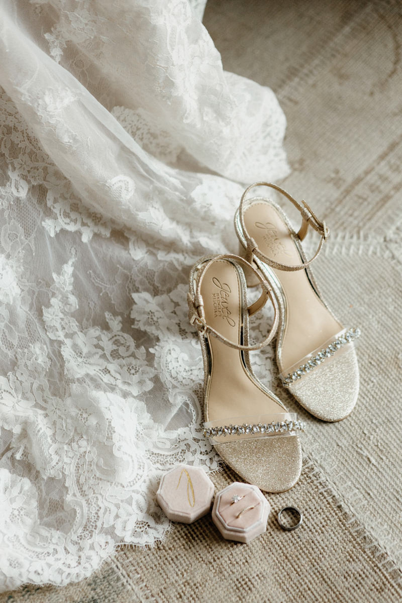 Wedding rings and diamond studded heels with a lace wedding dress train