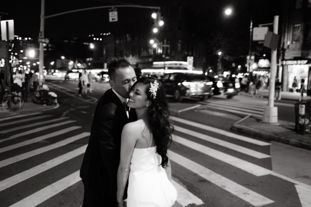 A bride and groom kissing after their wedding in the streets of Manhattan