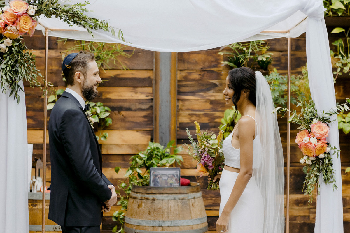 A Jewish groom and bride share their vows with guests virtually