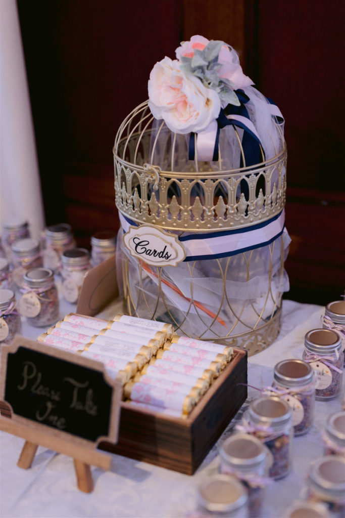 A metal cage holding cards addressed to the bride and groom