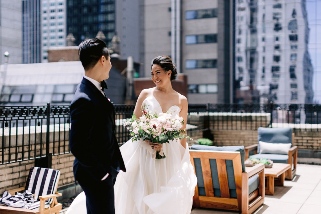 A bride looks at her groom on a rooftop in NYC