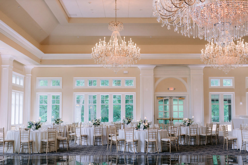 A large bright room with circular tables for a wedding reception