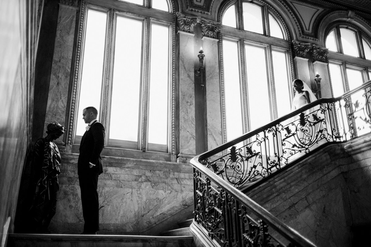The bride is going down the stairs to the groom. Image by Jenny Fu Best wedding photographers in NYC