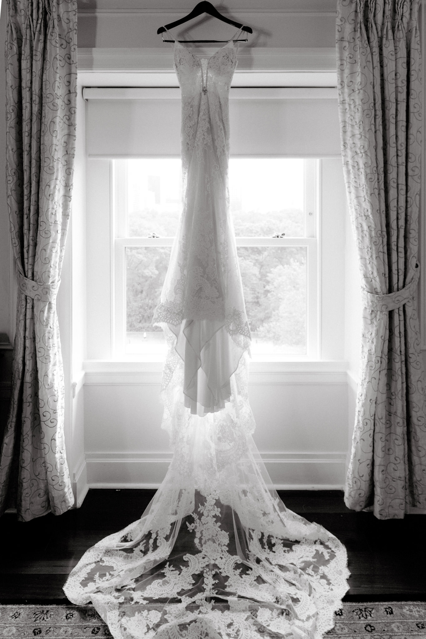 Wedding photographer Jenny Fu takes a photo of a wedding dress hanging in a window