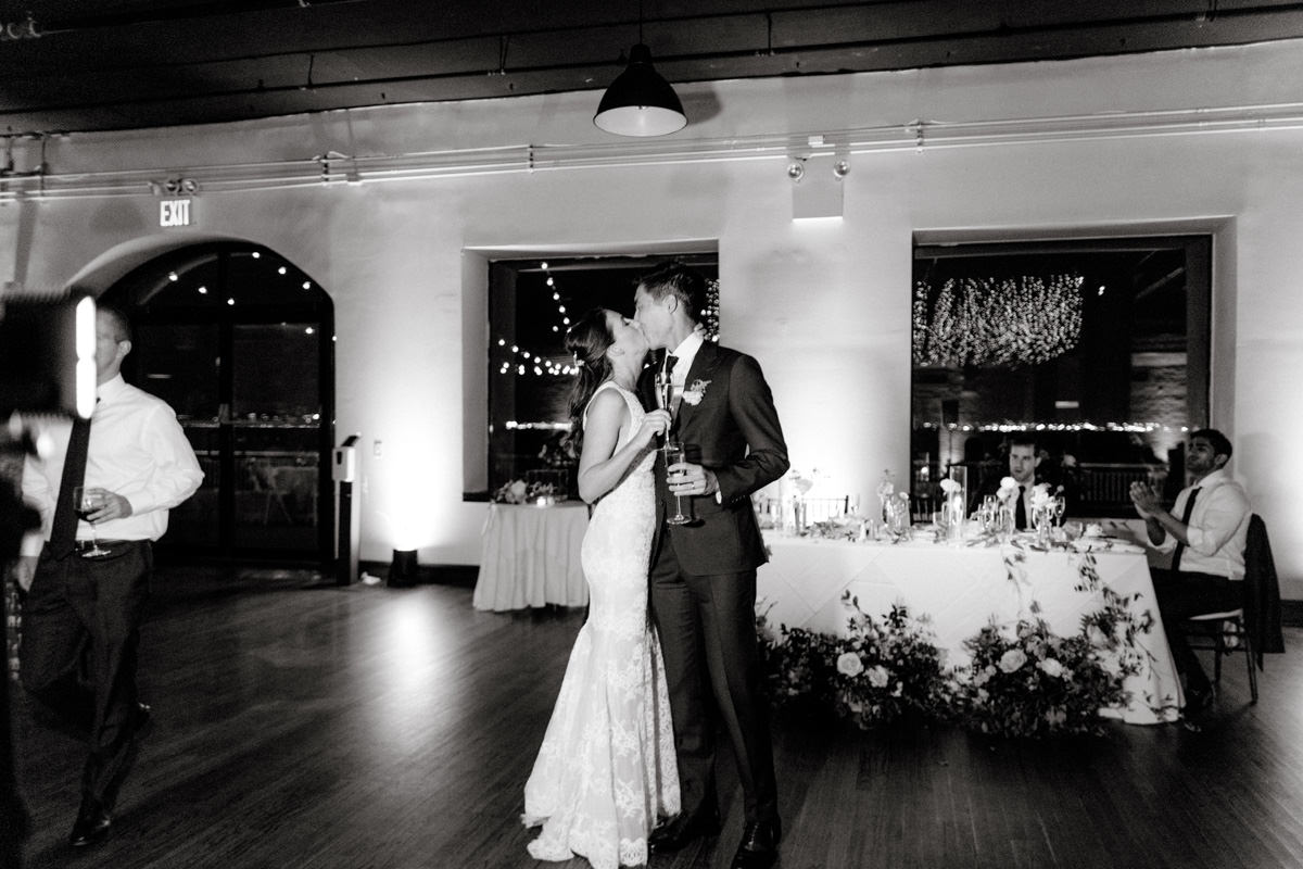 The bride and the groom kiss in the middle of the dance floor in Liberty Warehouse. Image by wedding photographer Jenny Fu
