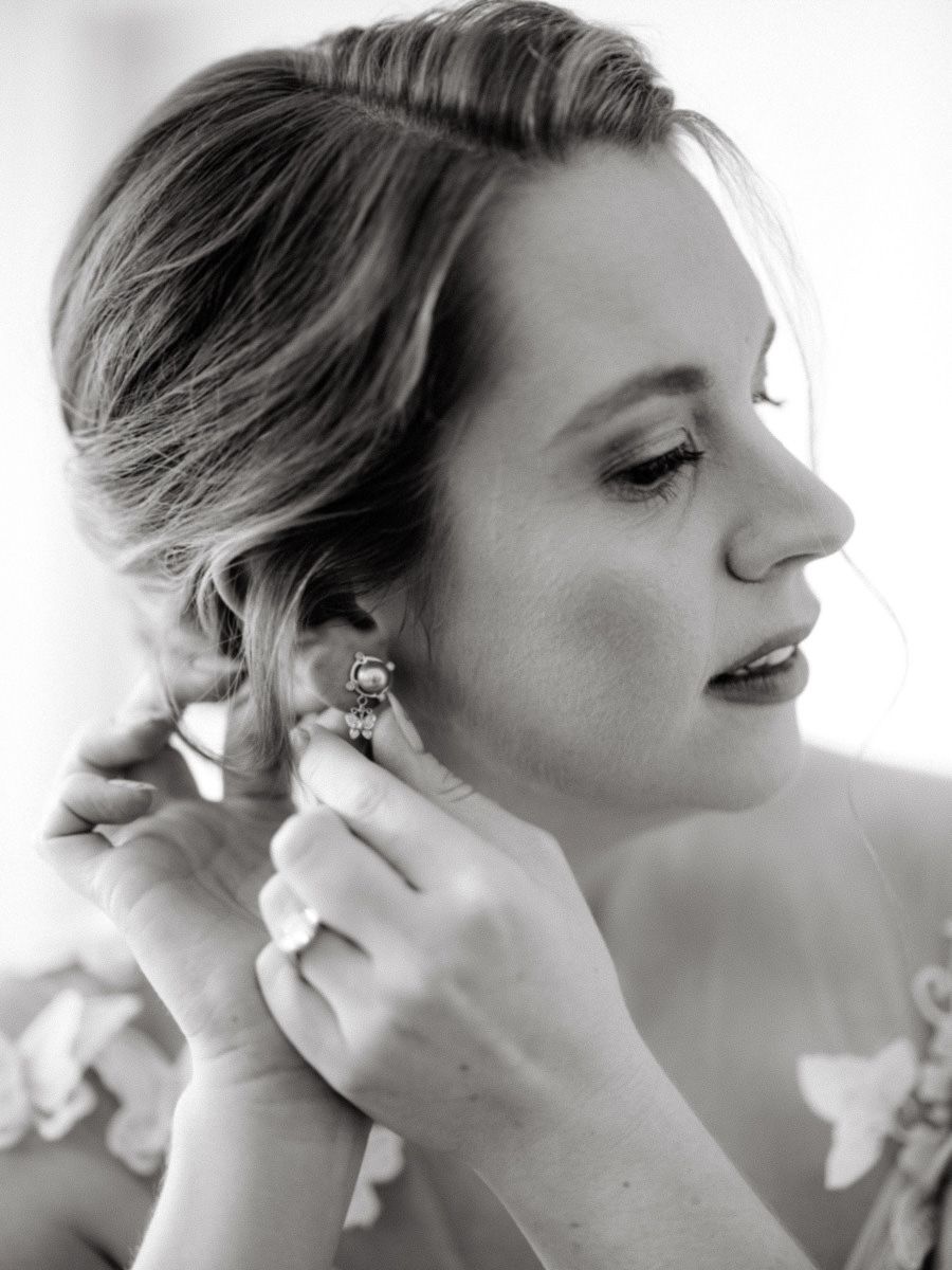 A bride putting on her earring.