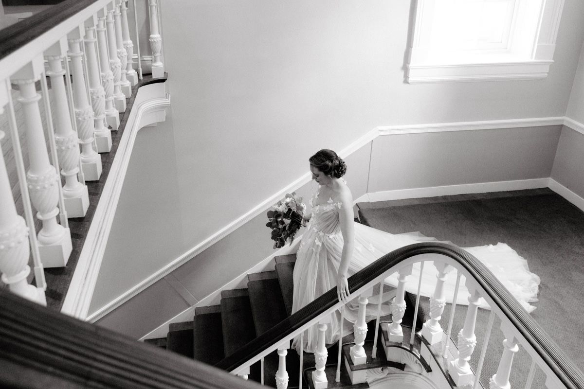 Bride holding her flower bouquet, going down the stairs