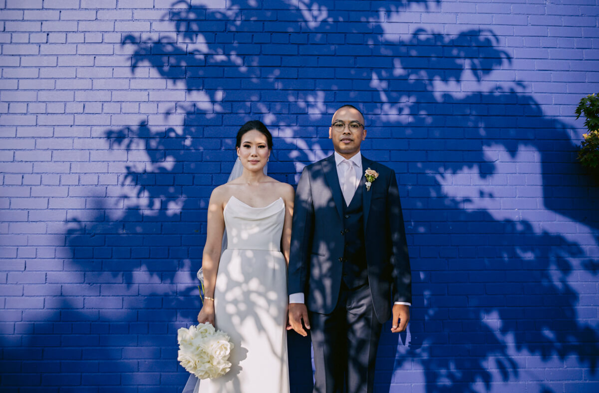 Bride and Groom with a blue brick wall on the background