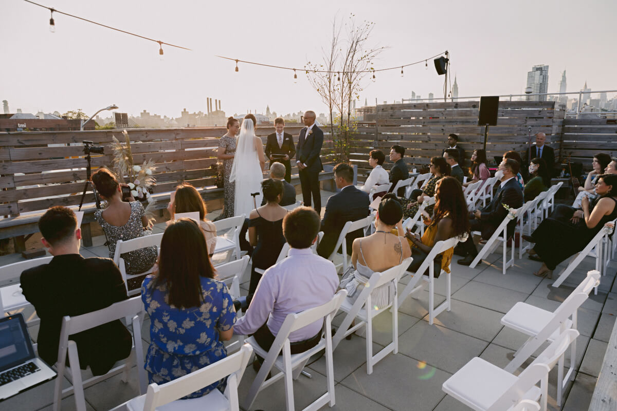 Bride and groom saying their vows while seated guests watch on