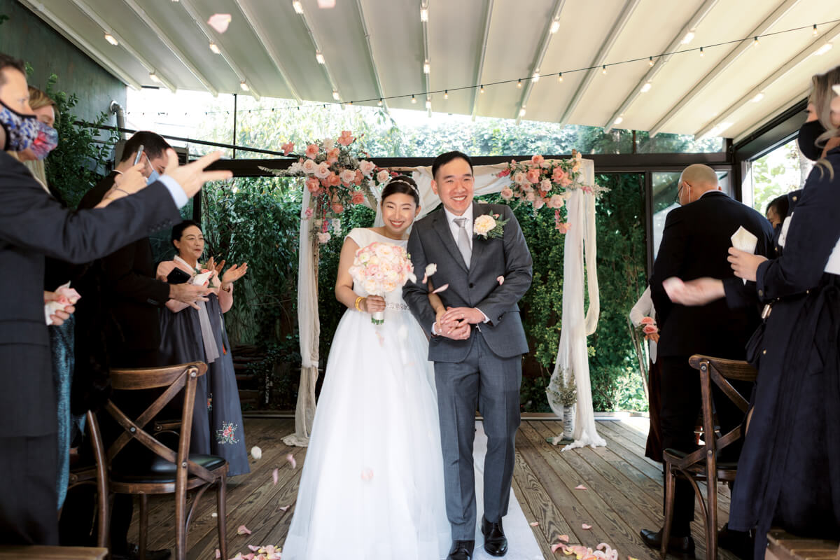 The bride and groom are happily walking back the aisle in NYC. Image by Jenny Fu Studio 
