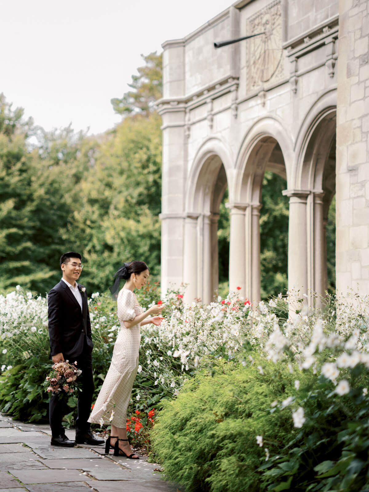 The bride and the groom are amidst the beautiful flowers in Planting Fields Arboretum, Oyster Bay, NY. Image by Jenny Fu Studio