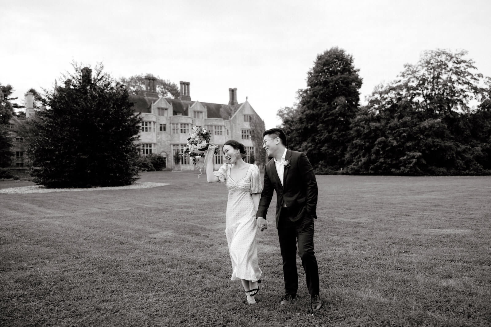 The bride and the groom are happily walking on the grounds of Planting Fields Arboretum, Oyster Bay, NY. Image by Jenny Fu Studio