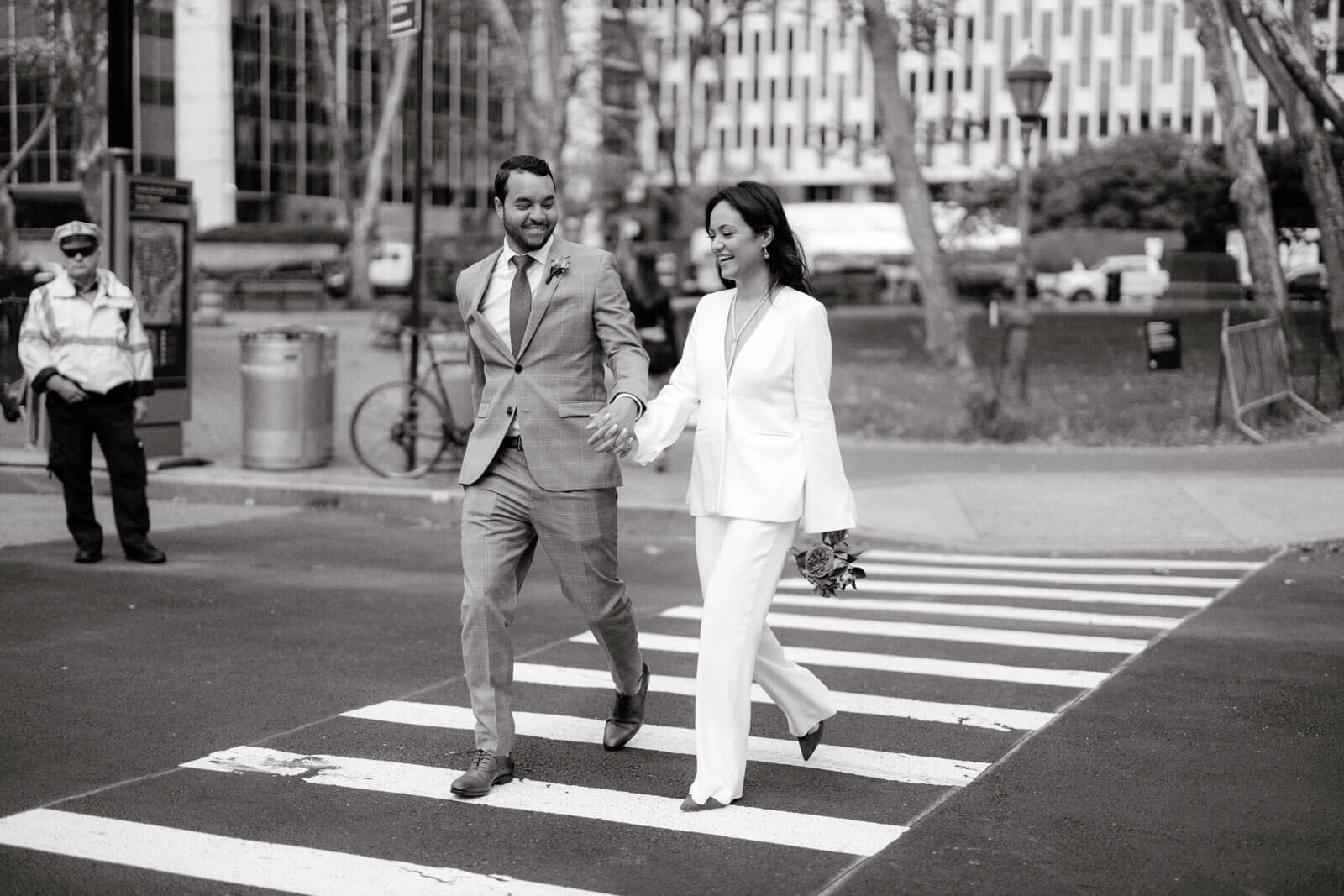 Black and white photo of the bride and the groom crossing the street in New York City.