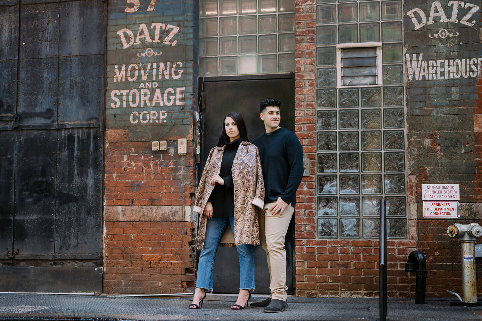 Engagement photos: An engaged couple are standing in the streets of Tribeca, New York City.