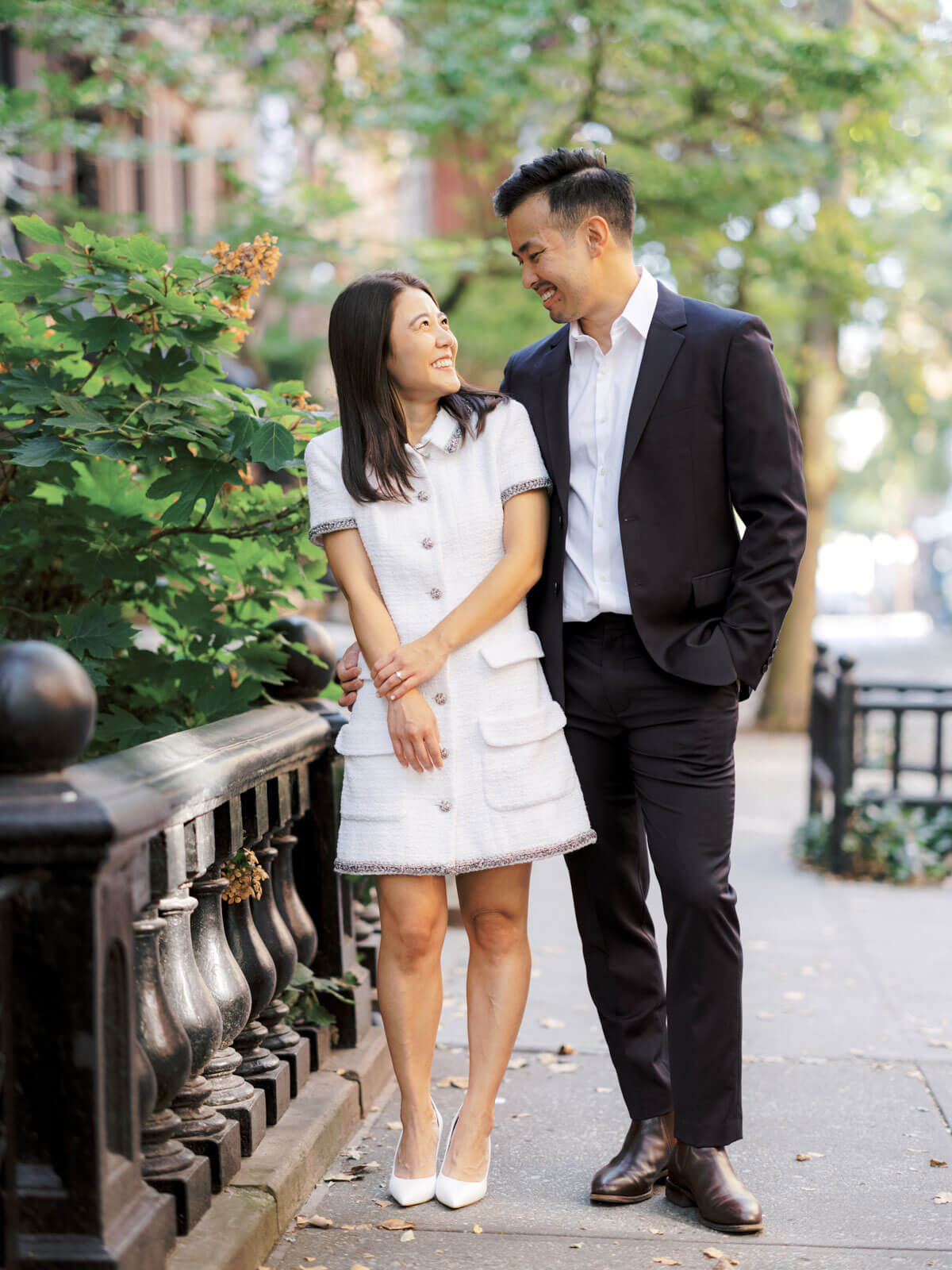 The engaged couple is looking happily at each other at West Village, NYC. Image by Jenny Fu Studio