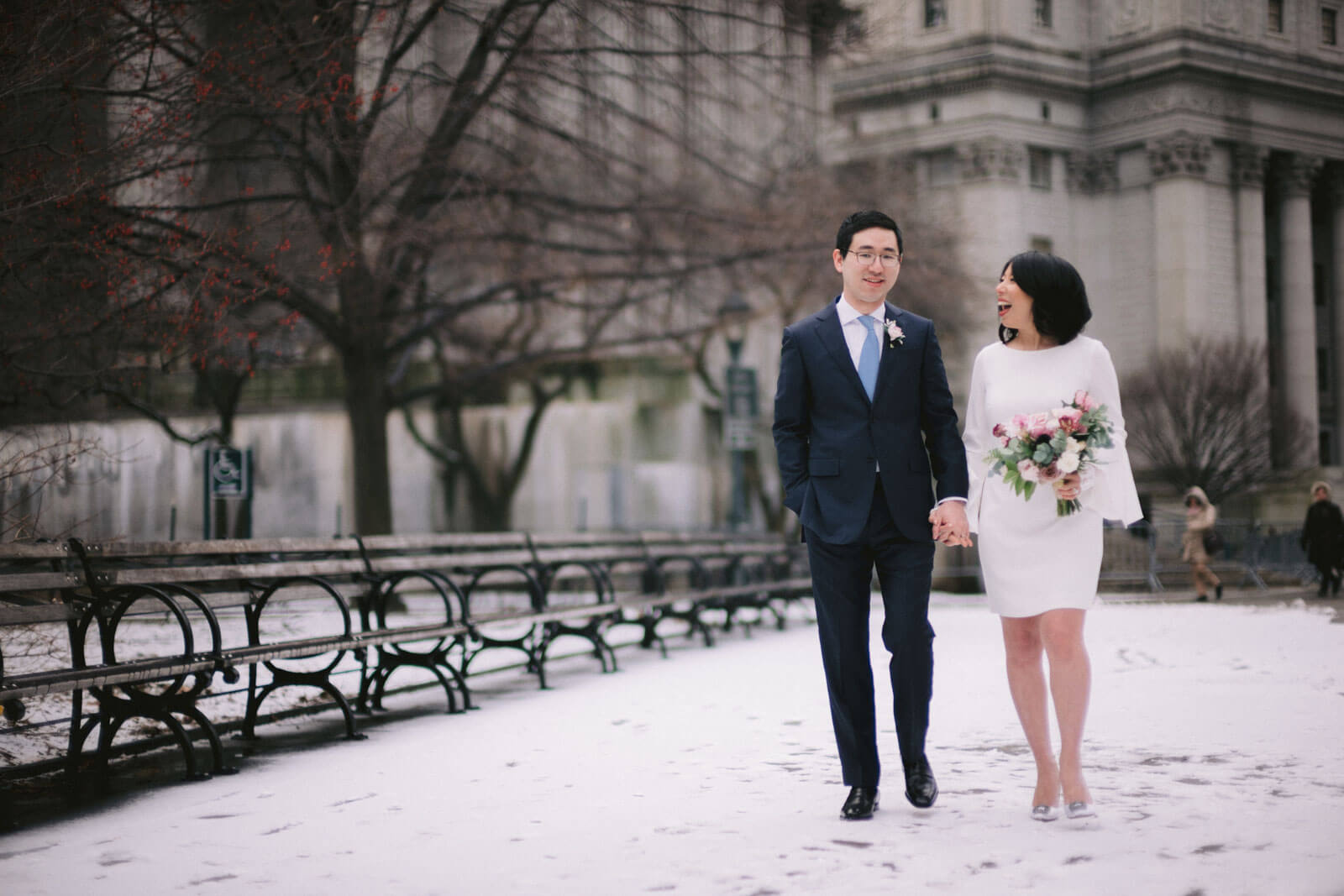 The bride and groom are happily walking in the park, having a winter wedding in New York. Image by Jenny Fu Studio  