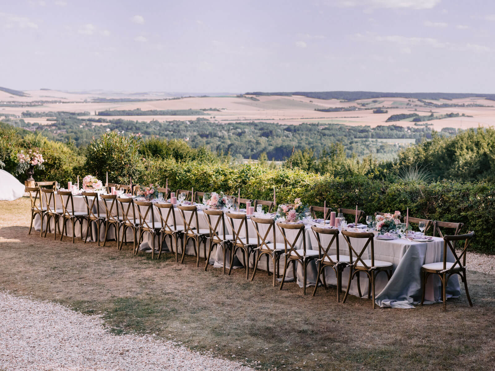 A rustic long dinner table outdoors, overlooking the estate in France. Image by Destination Wedding Photographer Jenny Fu