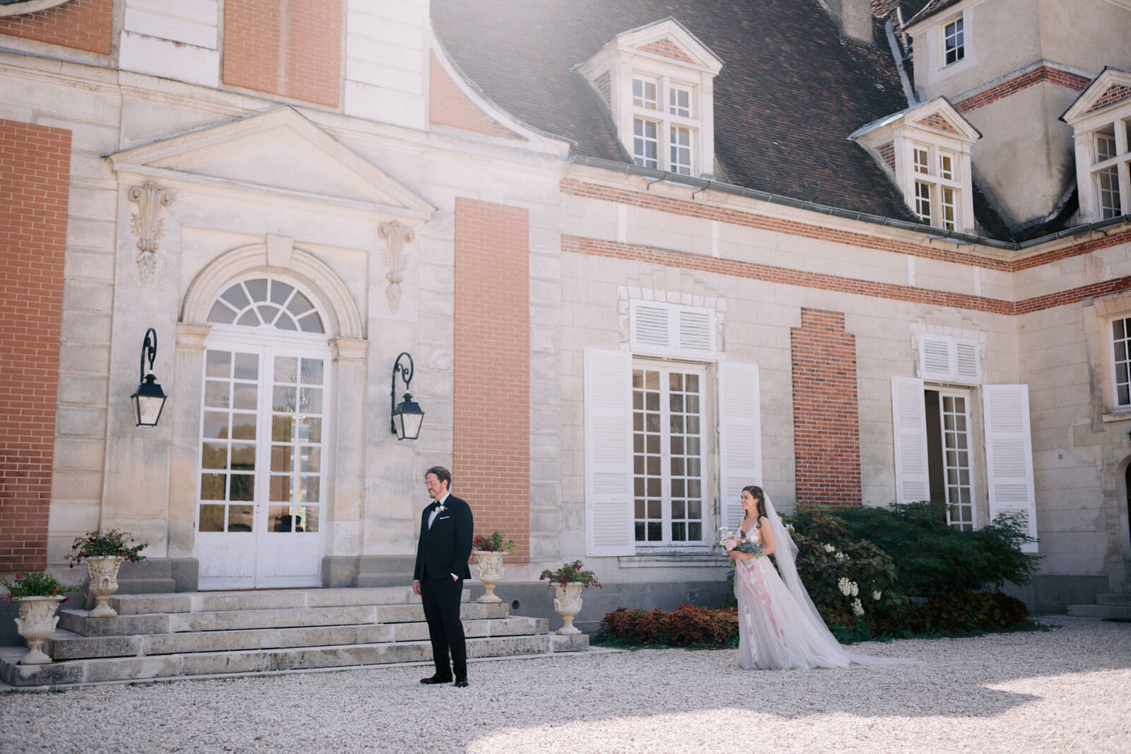 First look of the bride and the groom in front of a castle. Best outdoor lover's wedding destination. Image by Jenny Fu