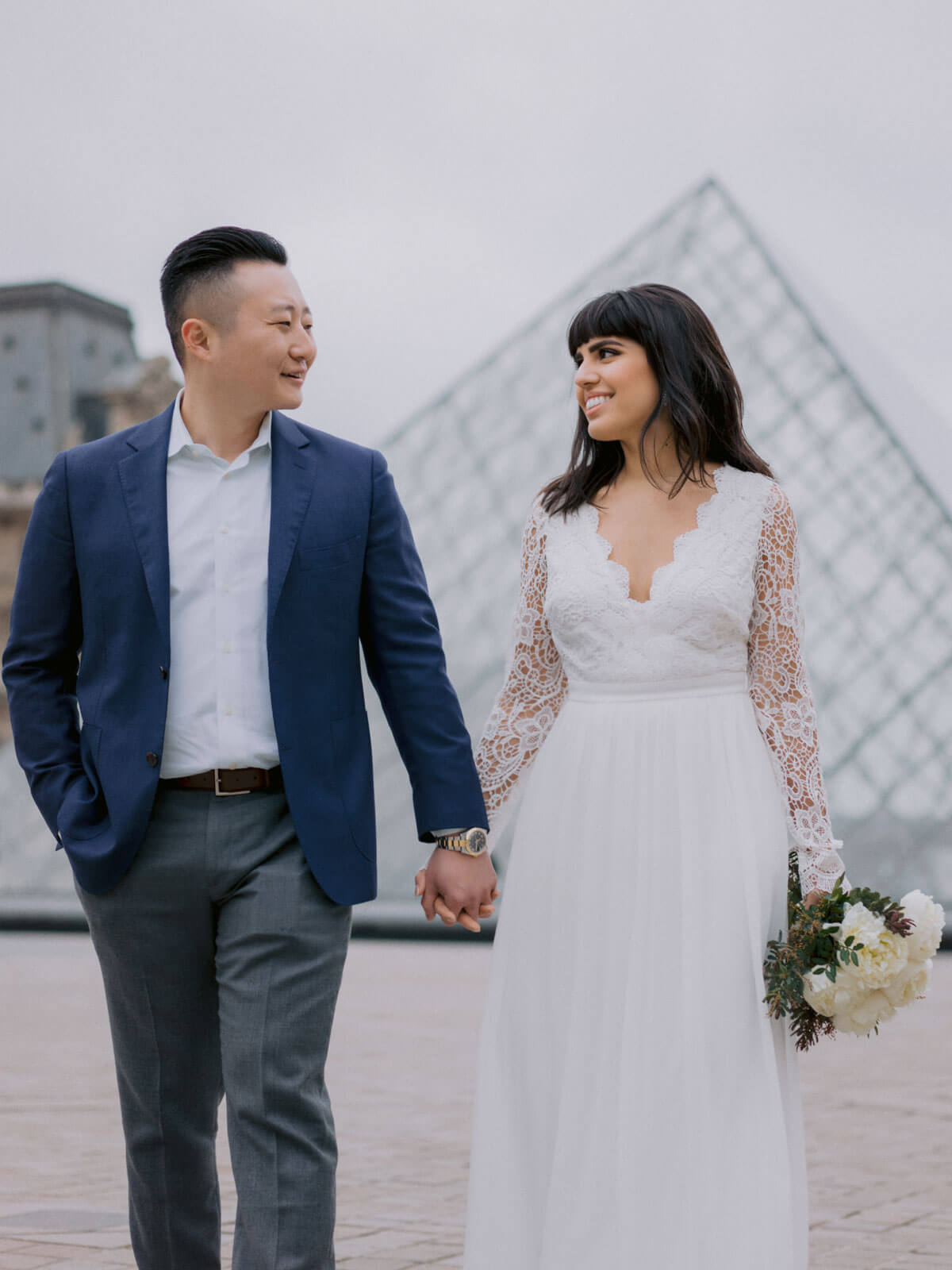 The bride and groom are happily looking at each other in Paris, France. Destination wedding image by Jenny Fu Studio