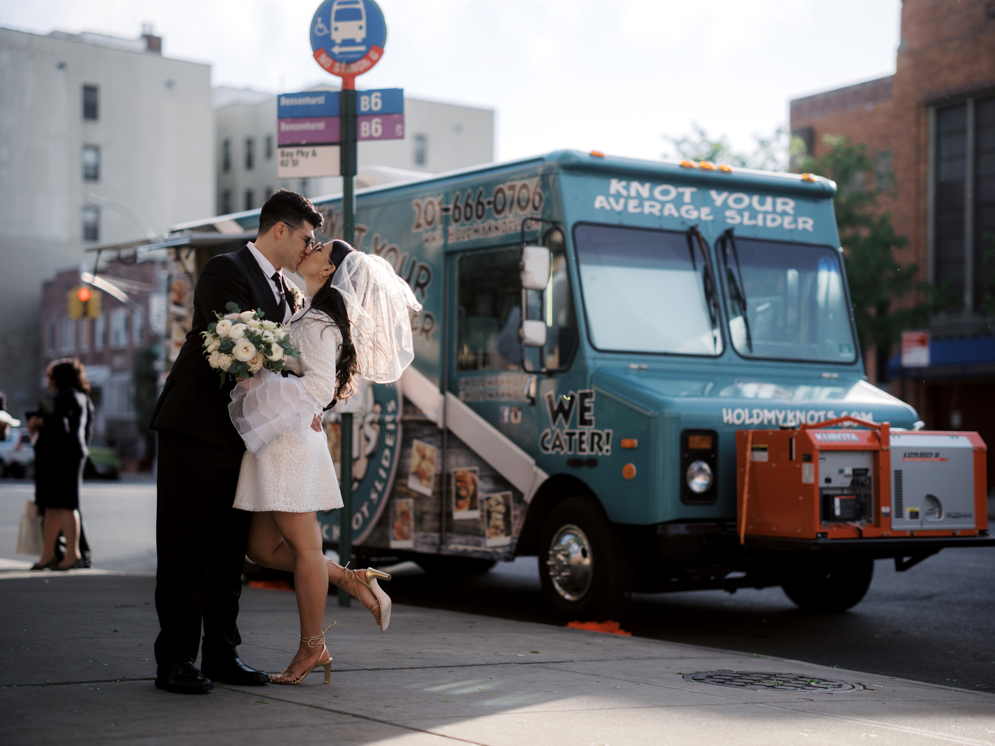 The bride and groom are kissing in front of a food truck. Image by Jenny Fu Studio