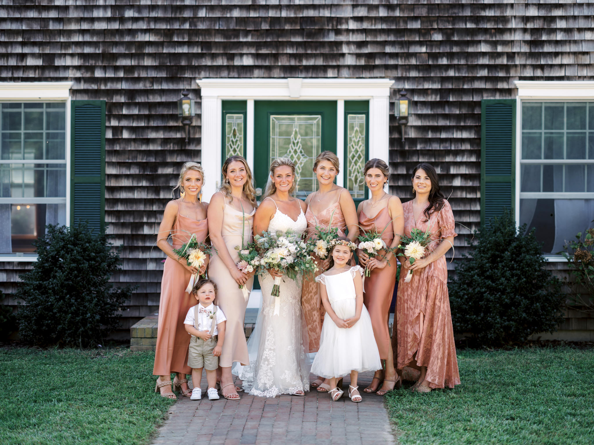 The bride, bridesmaids, flower girl, and ring bearer are in front of a house. 2022 wedding trends image by Jenny Fu Studio 