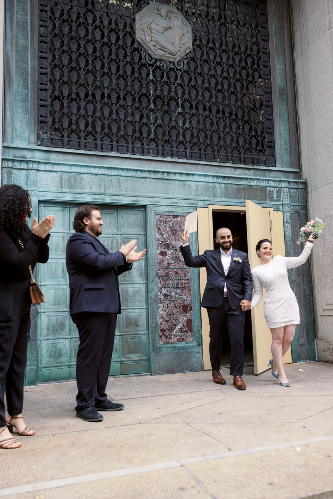The bride and groom happily went out of the exit room in the City Clerk's Office. NY City Hall Elopement image by Jenny Fu Studio