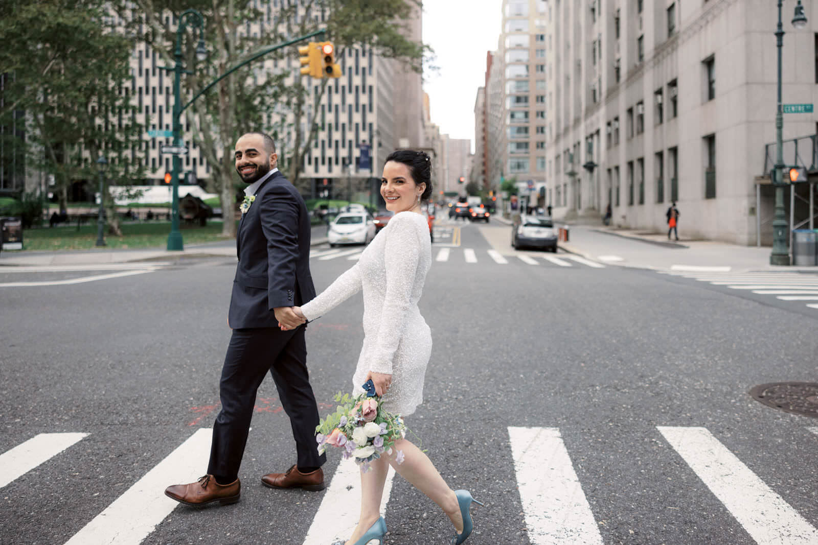 The bride and groom are crossing the street in New York. NYC City Hall Elopement image by Jenny Fu Studio
