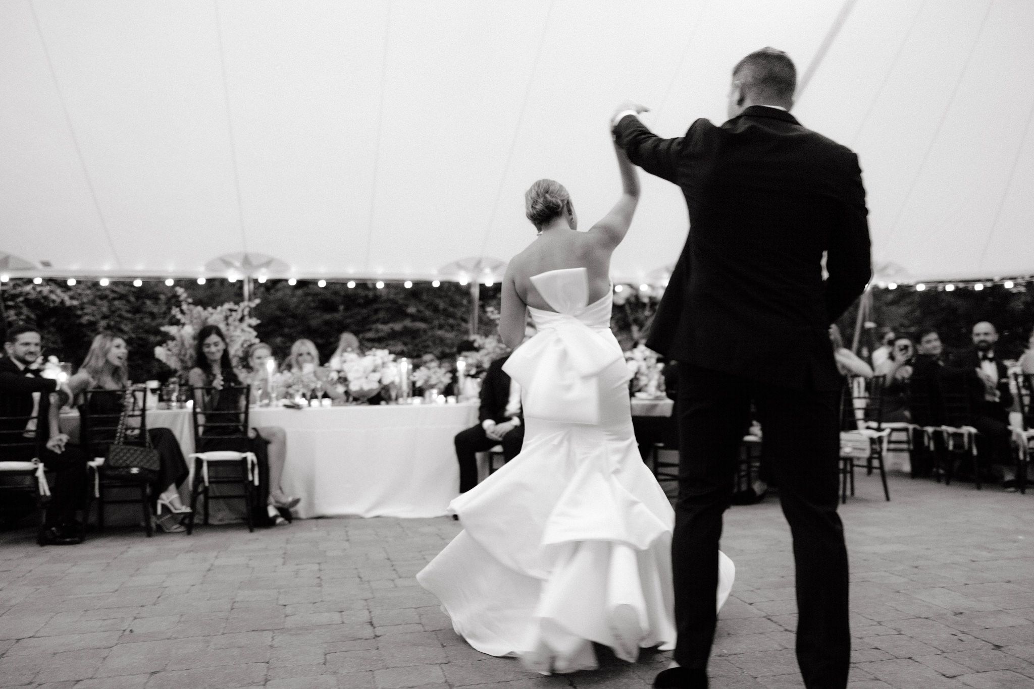 Black and white photo of the bride and groom dancing for their first dance. Destination image by Jenny Fu Studio