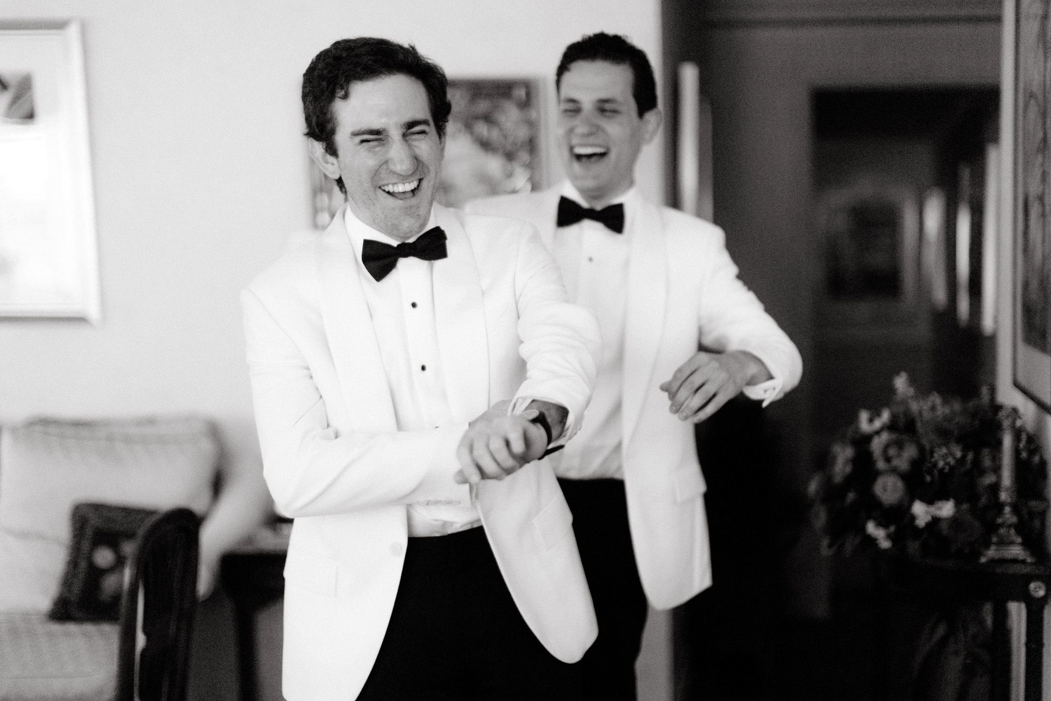 The 2022 groom is laughing with a groomsman. Image by Jenny Fu Studio