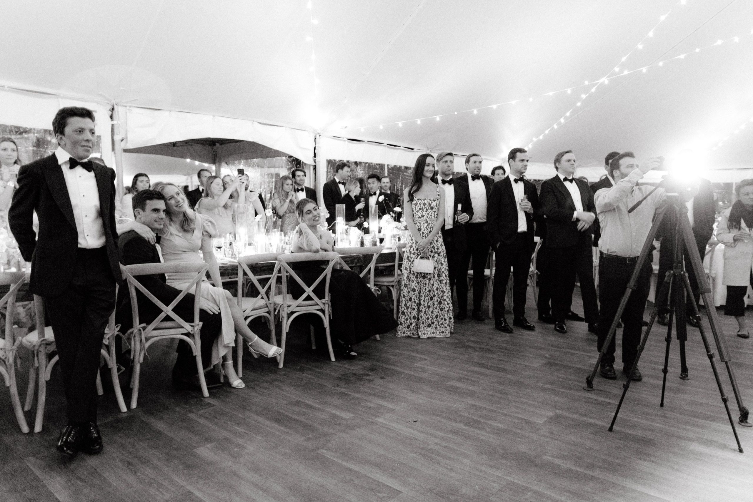 The wedding guests watch and the videographer shoots someone on the stage. Best NYC wedding vendors Image by Jenny Fu Studio.
