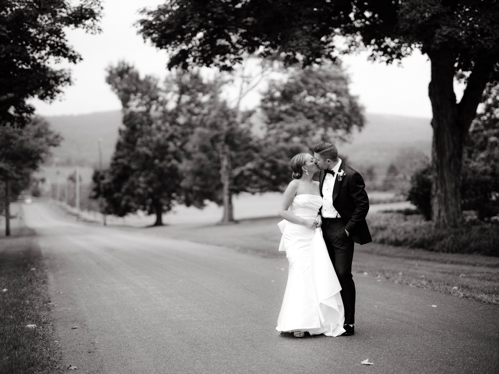 Black and white photo of the bride and groom kissing in a ranch. Image by Destination wedding photographer Jenny Fu 