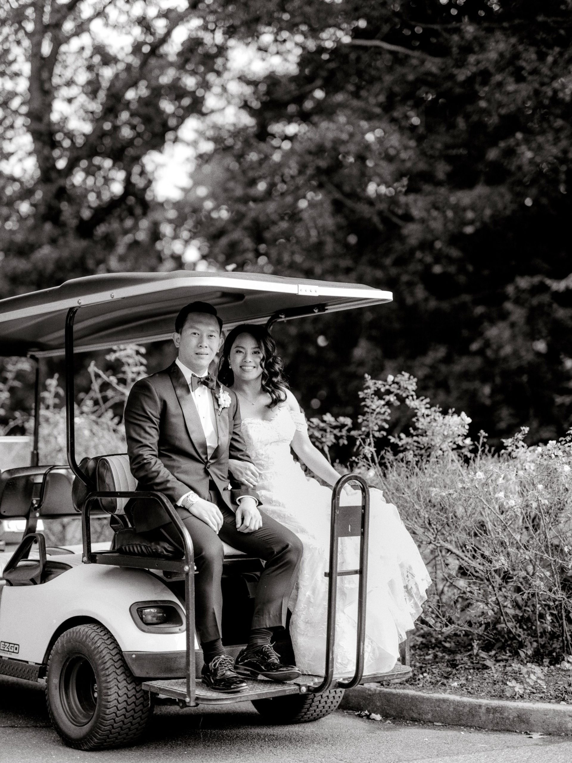 The bride and the groom are sitting on a golf cart inside The Brooklyn Botanic Garden. Hiring a wedding planner image by Jenny Fu Studio