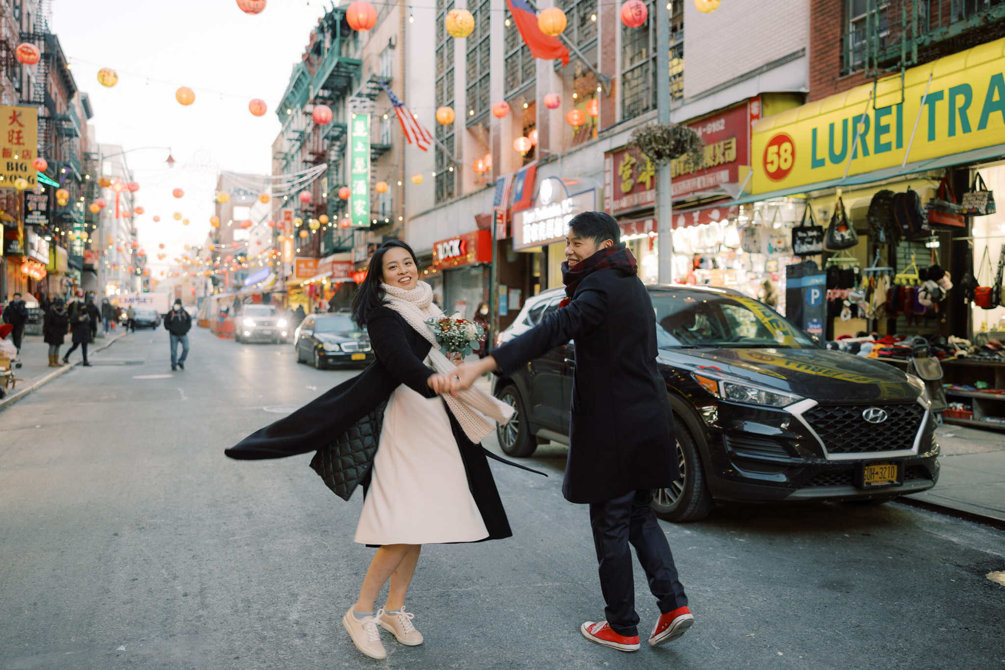 The bride and groom are walking at Chinatown after their 2022 city hall wedding in NYC. Photo by Jenny Fu Studio