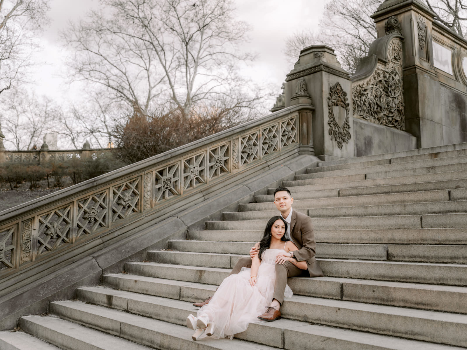 Chic and stylish couple sitting on a staircase at Central Park, New York City. Editorial Engagement session image by Jenny Fu Studio
