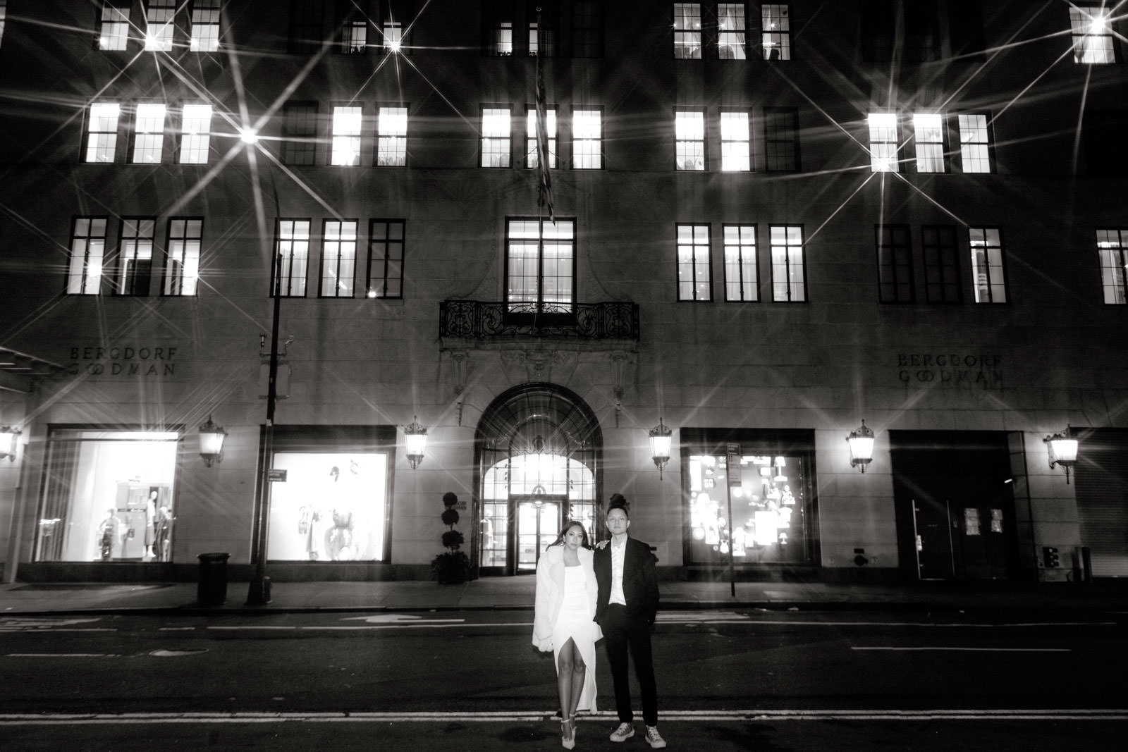 The engaged couple is standing in front of Berdorf Goodman, New York City. Editorial night engagement photo by Jenny Fu Studio