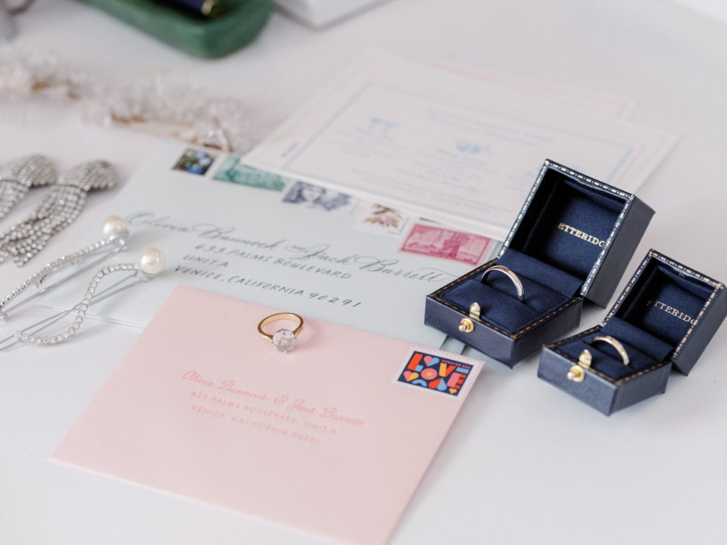 Invitation cards and the bride's jewelry at The Ausable Club, New York. Image by Jenny Fu Studio