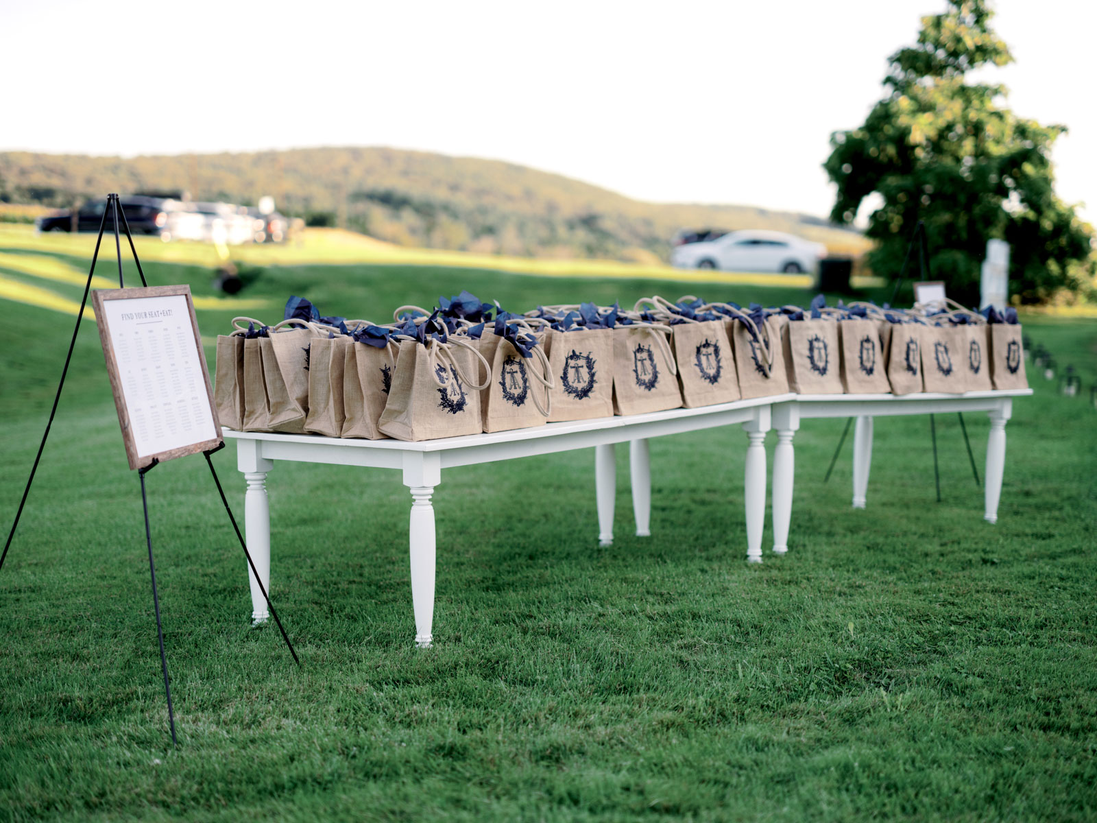 A bunch of welcome gifts for wedding guests are on a table outdoors at Lion Rock Farm. Destination wedding image by Jenny Fu Studio