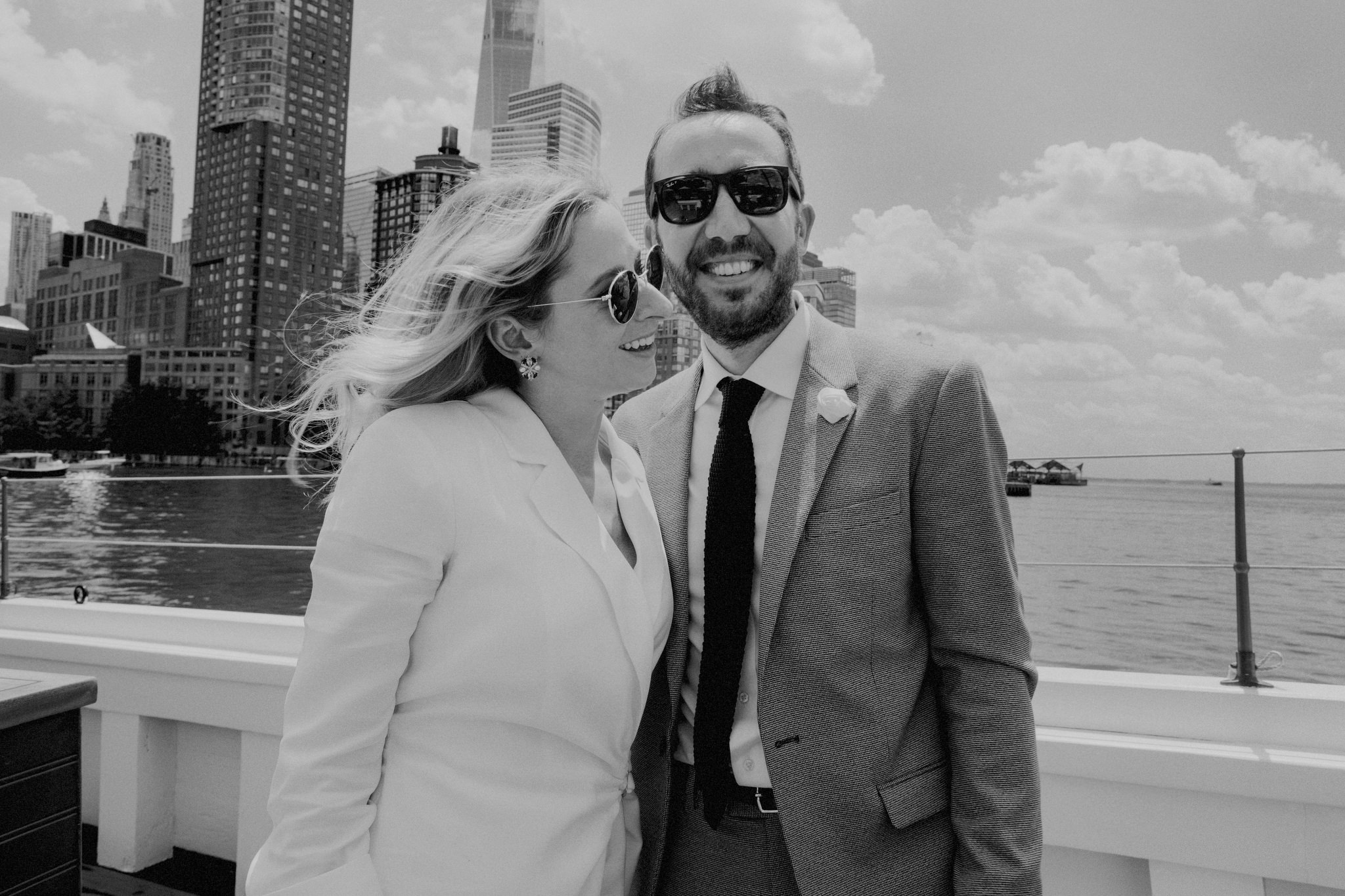 The bride and groom are enjoying the view at the New York harbor while cruising on a boat. Intimate wedding image by Jenny Fu Studio