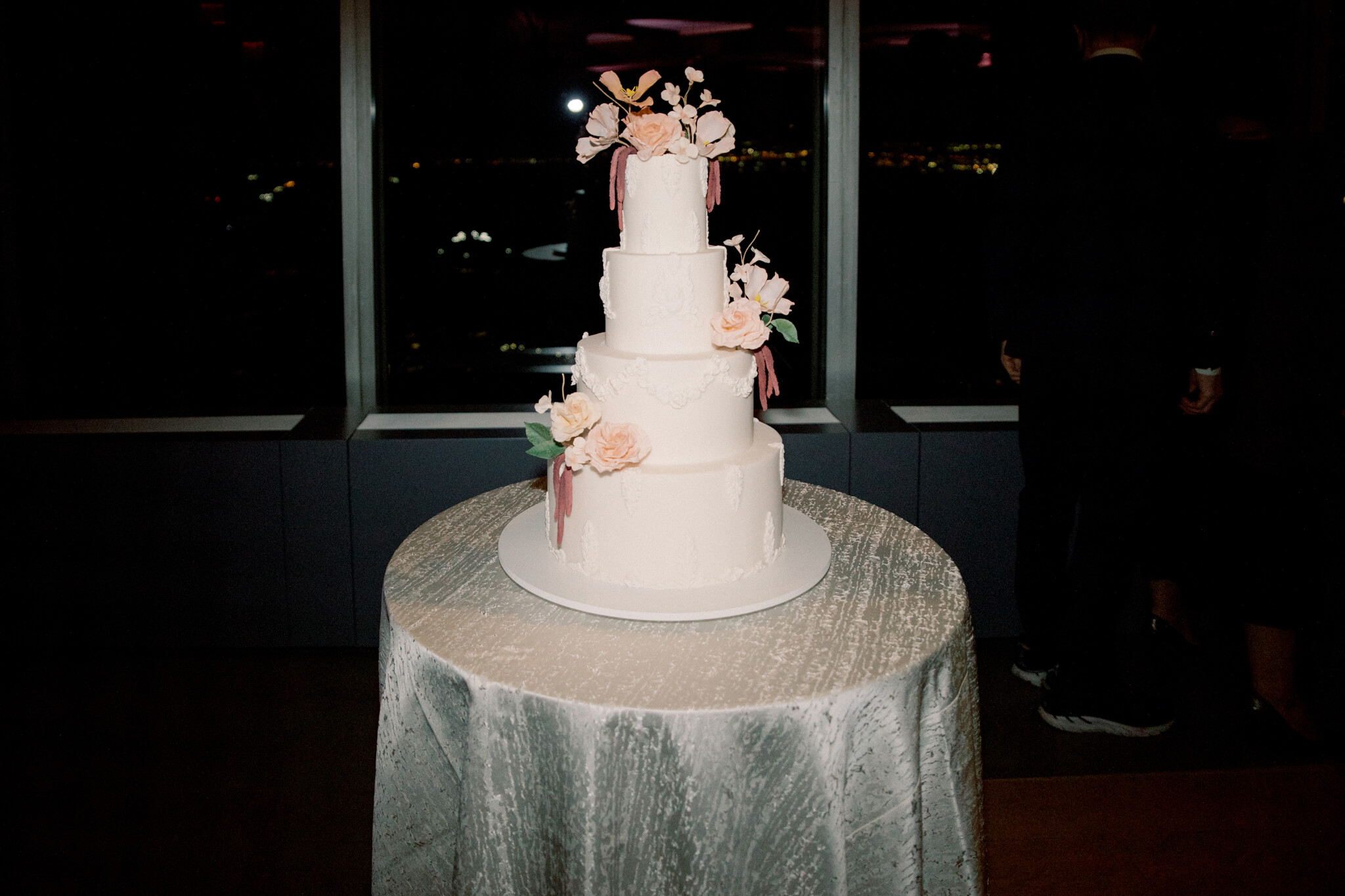 A simple and pretty four-layer wedding cake at Manhatta Restaurant, NYC. Image by Jenny Fu Studio