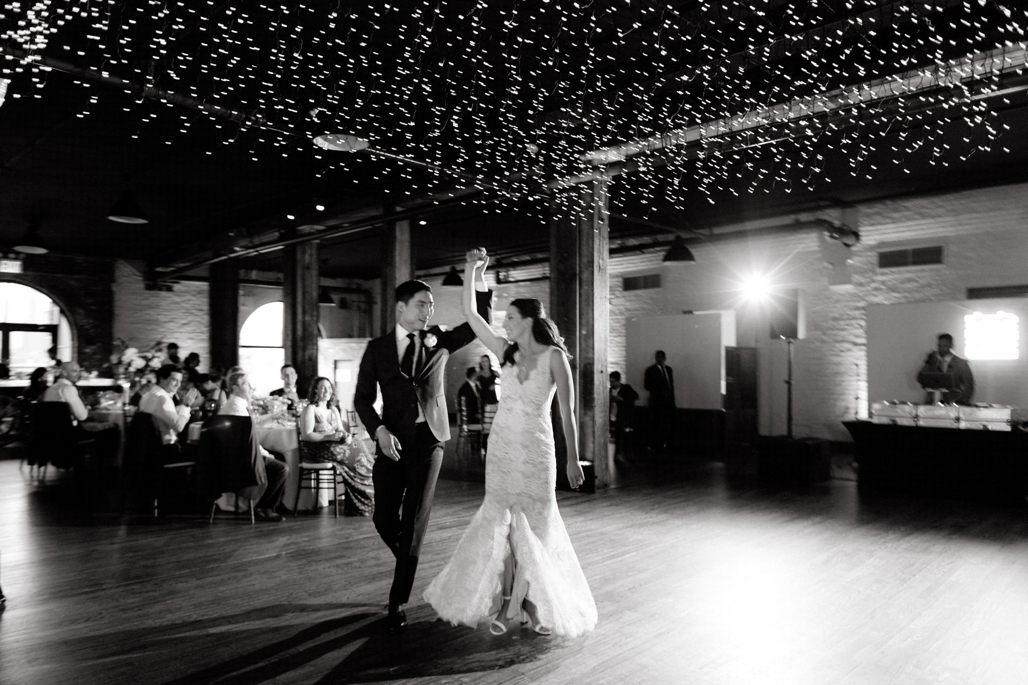 Editorial wedding photo of the bride and groom dancing as the guests watch them. NYC wedding venue image by Jenny Fu Studio